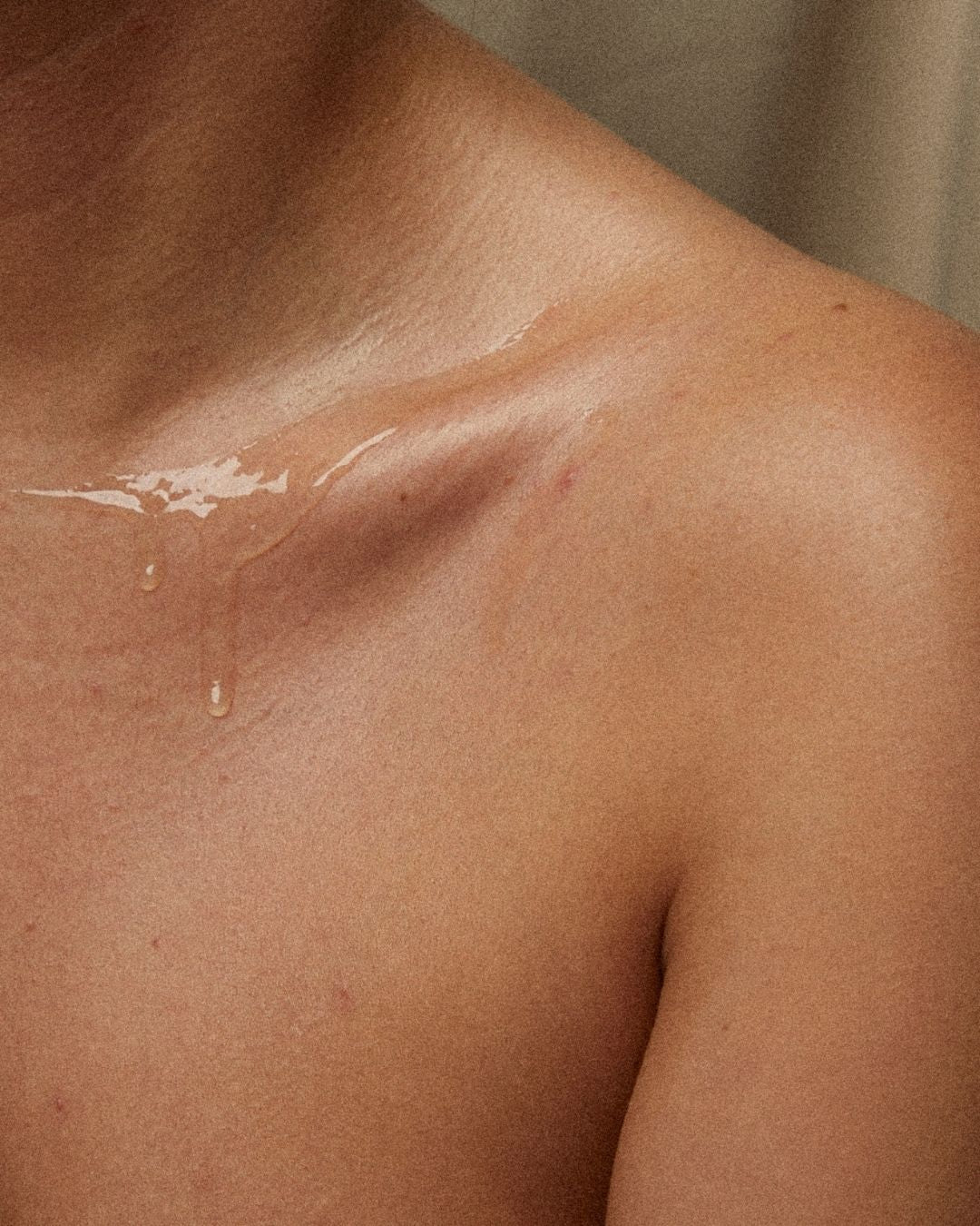 Épaule et clavicule d’une femme où l’huile fait briller la peau
