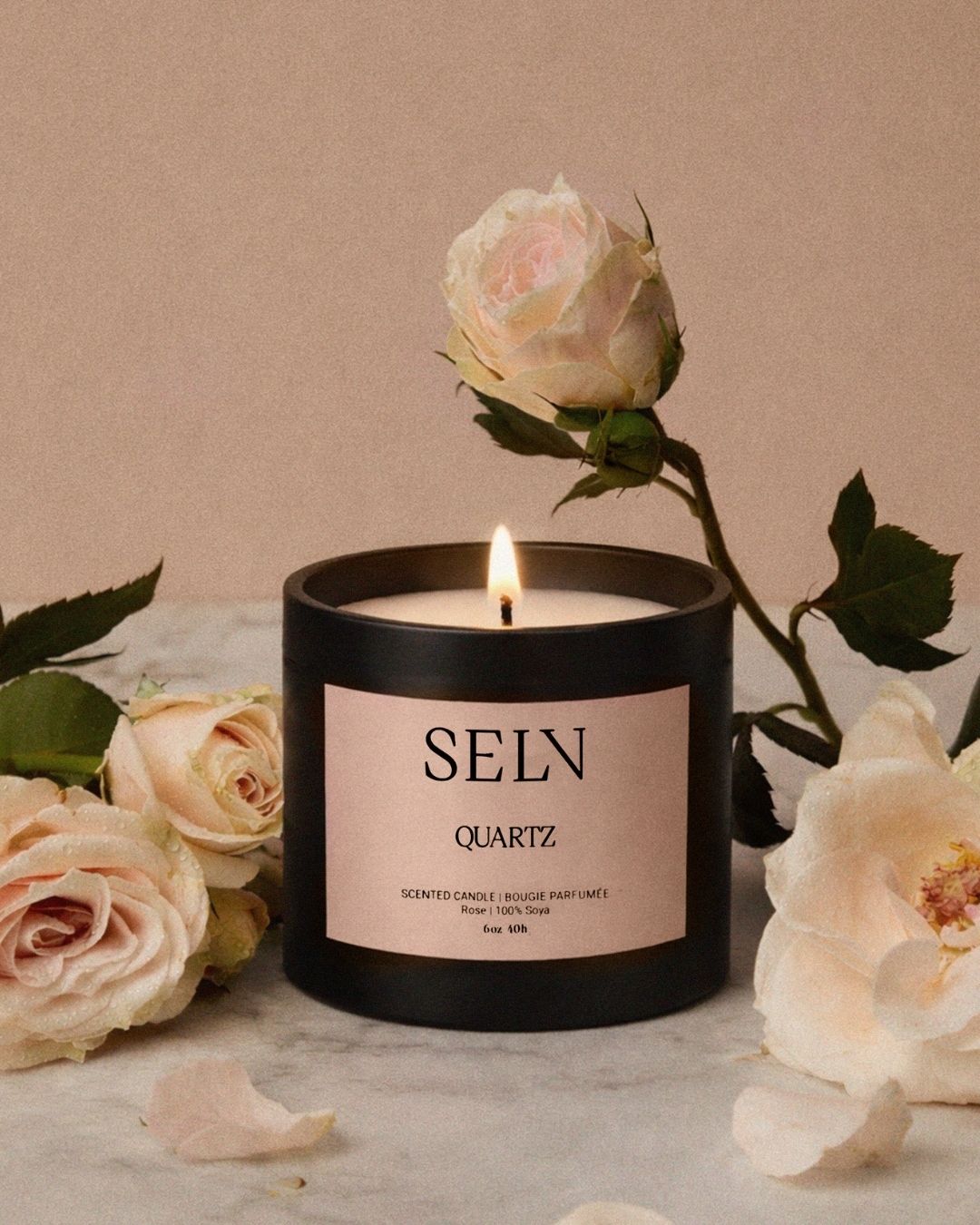 Chandelle Selv Quartz allumée, entourée de roses